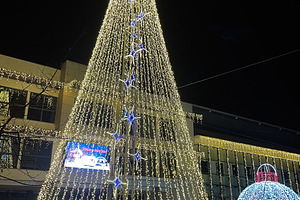 Illuminated Christmas tree and decorations at night in festive city center in M, a Photo by AS photostudio