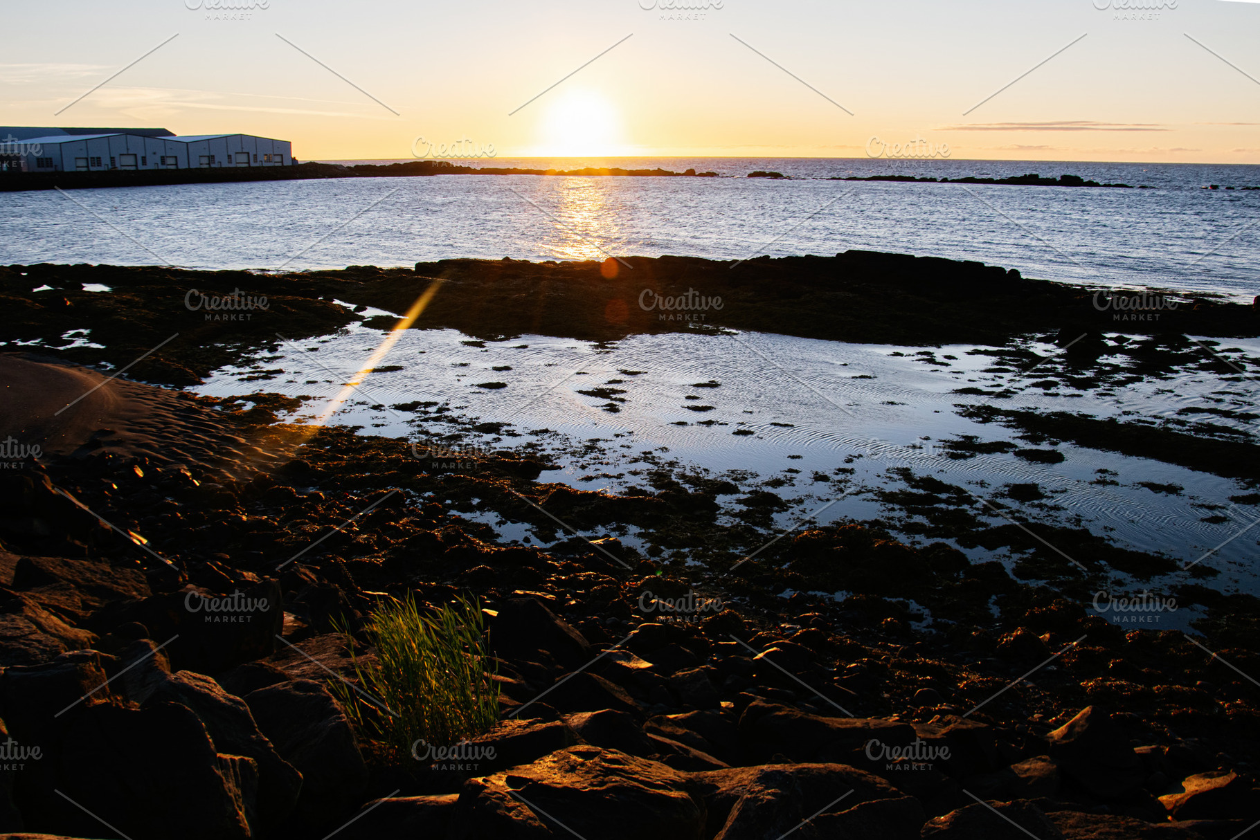 Sunset over a rocky shoreline and calm waters in scenic Iceland, a Nature Photo by AS photostudio