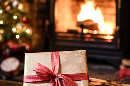 Christmas gift box near cosy fireplace in the English country co, a Photo by Anneleven