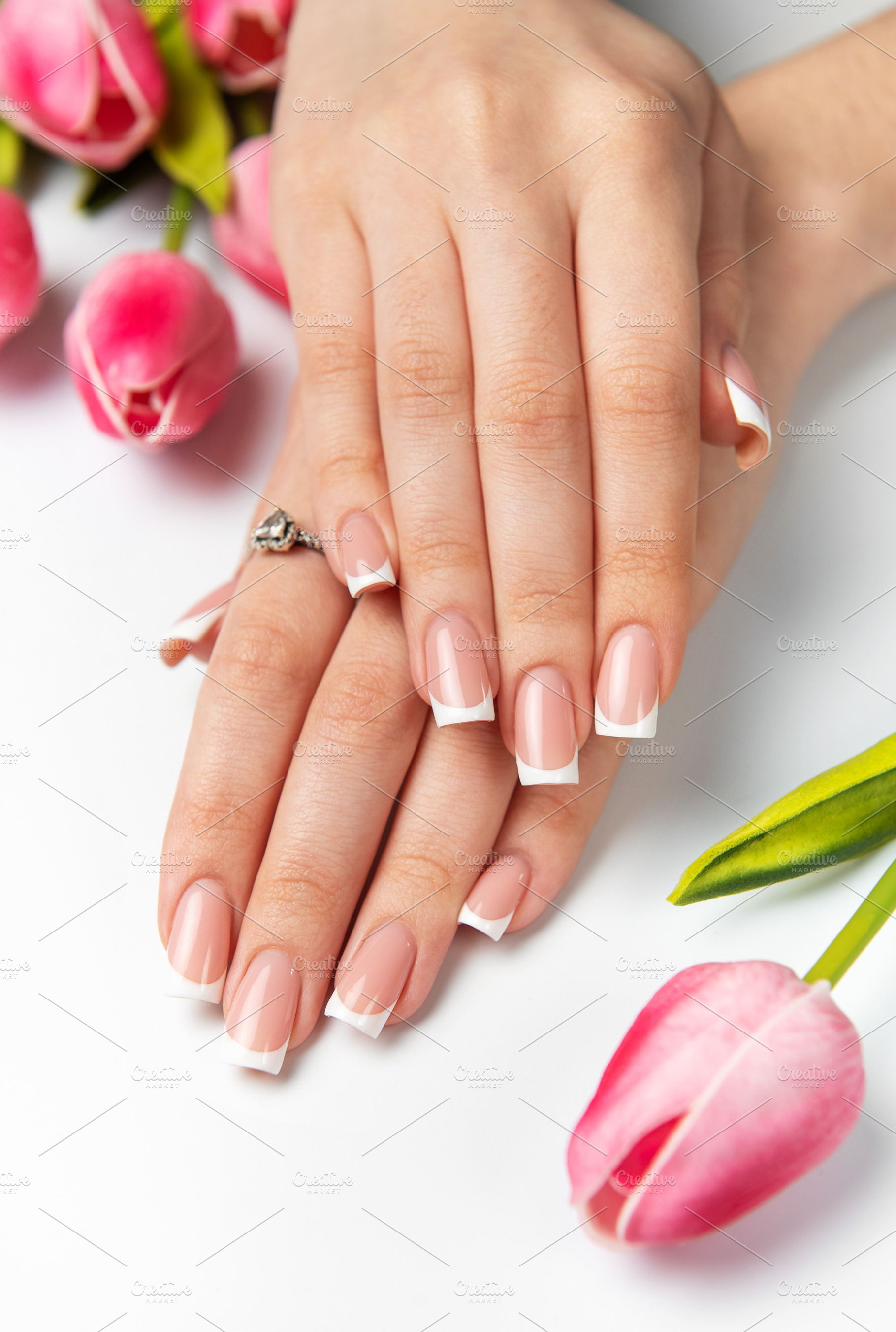 Woman showing french manicure and pink tulips on white backgroun, a Beauty & Fashion Photo by Olena Rudo