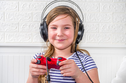 Llittle child kid girl playing video games, a Photo by Rimma