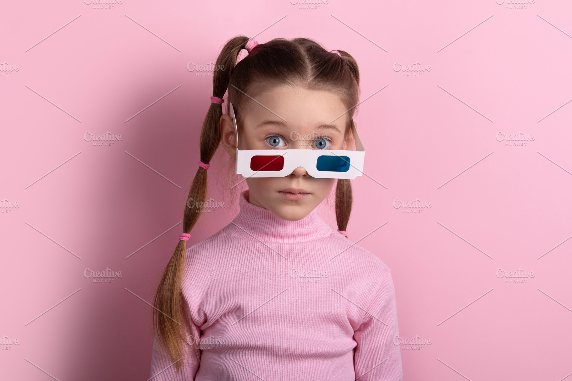 Young girl in a pink turtleneck and 3D glasses, standing against, a Person Photo by Ales Munt
