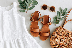 Light cotton summer outfit flat lay with accessories and greenery for a breezy, a Beauty & Fashion Photo by AlyaAnd