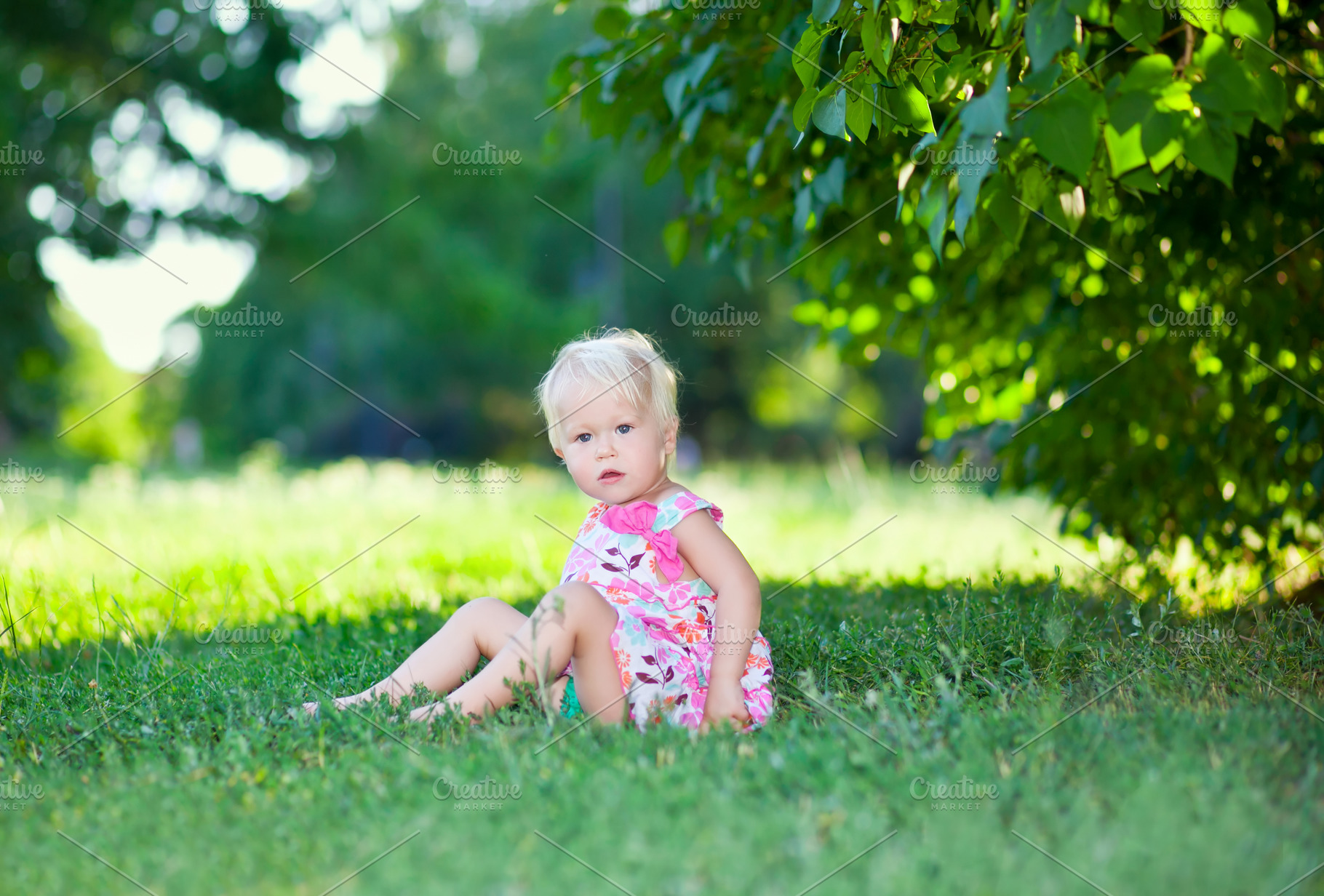 Baby sitting on green grass, a Photo by saiko3p