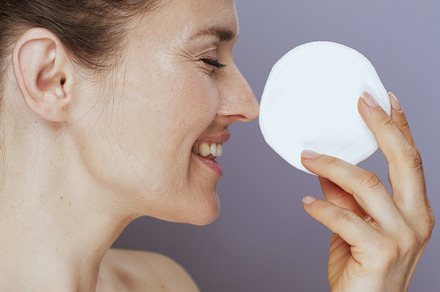 happy modern woman with cotton pad on blue, a Beauty & Fashion Photo by Alliance Images