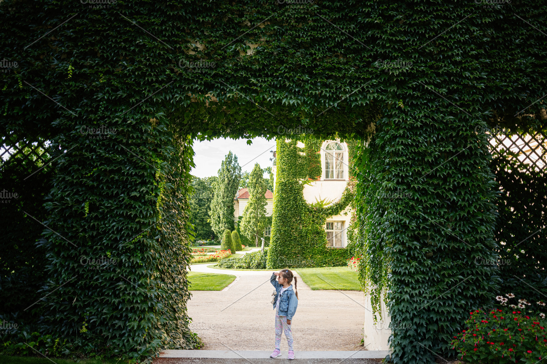 Lush green gateway with child exploring in Lancut, Poland's picturesque surroun, a Photo by AS photostudio