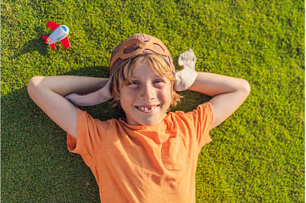 Boy wearing a pilot hat running