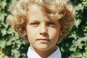 Cute boy with blonde curly hair and blue eyes, wearing a simple, a Person Photo by Studio ANNA