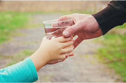 The father gives the child a glass, a Food & Drink Photo by yanadjana