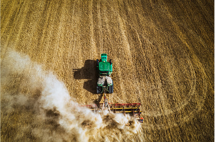 Aerial view of a harvester working, an Industrial Photo by HalfPoint