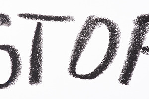 Word STOP is written in bold black pencil on white paper in a ha, an Abstract Photo by ndanko