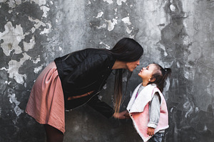 Mom and daughter are kissing