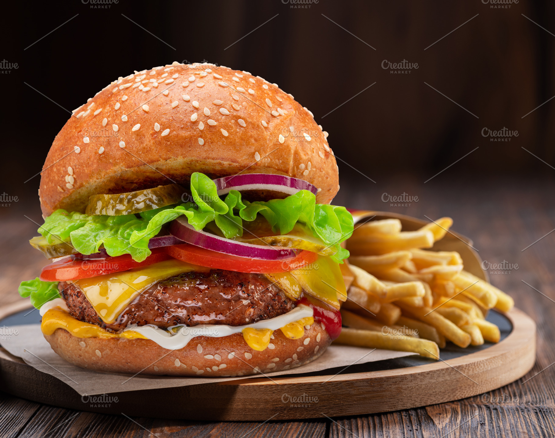 Tasty cheeseburger and french fries on wooden tray close-up., a Food & Drink Photo by Volff
