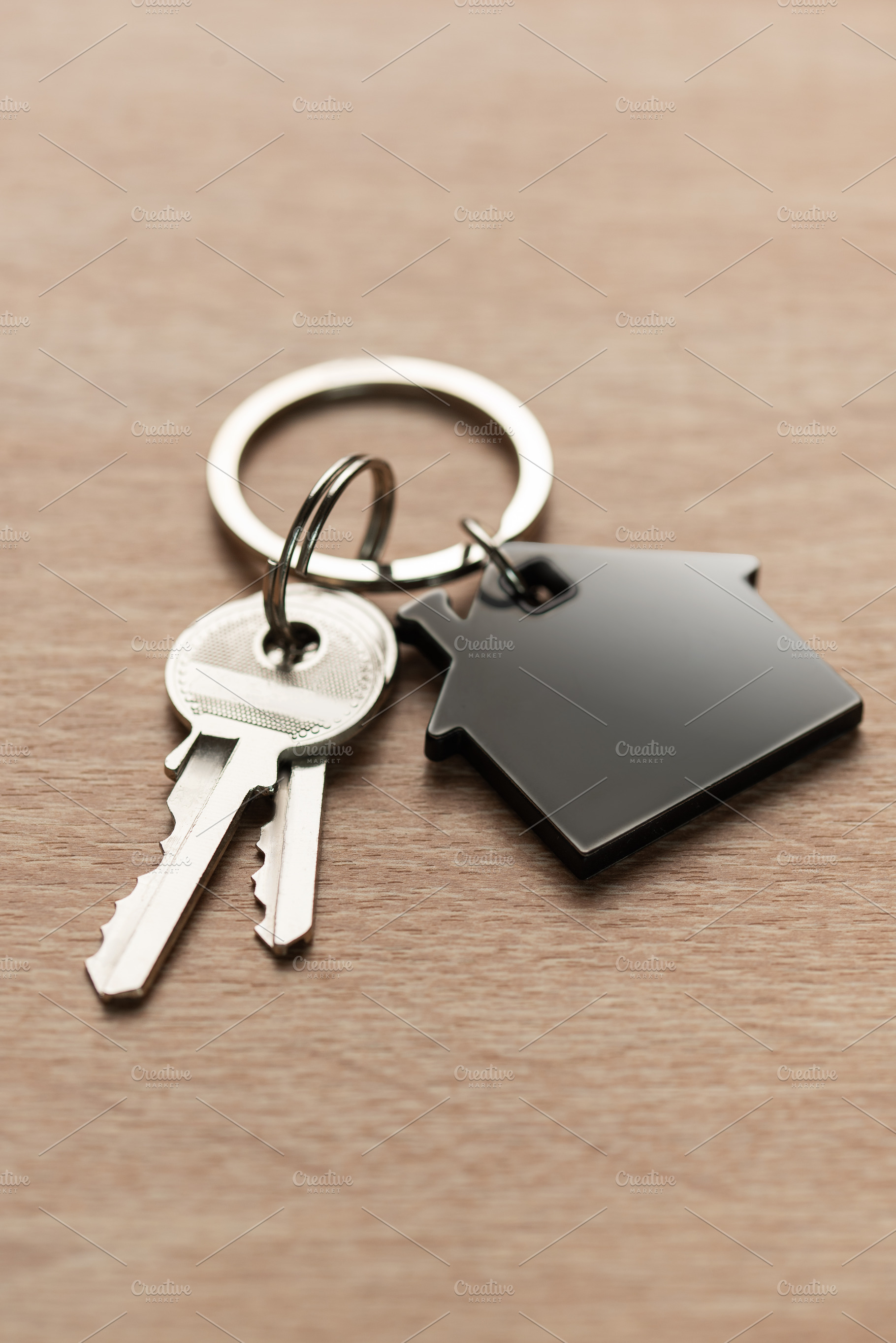 House keys with house shaped keychain on wood, a Business Photo by Olena Rudo