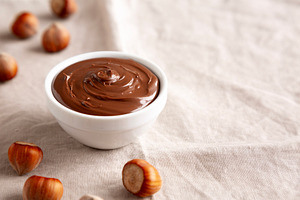 Homemade Chocolate Hazelnut Spread in a Bowl, side view. Copy sp, a Food & Drink Photo by LiudmylaChuhunova