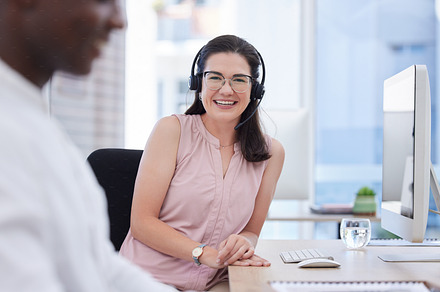 Woman, call center and portrait by pc in office desktop for consulting job with smile, vision and glasses, Crm expert, headphones and black man in tech support, customer service and contact us team, a Photo by Peopleimages.com