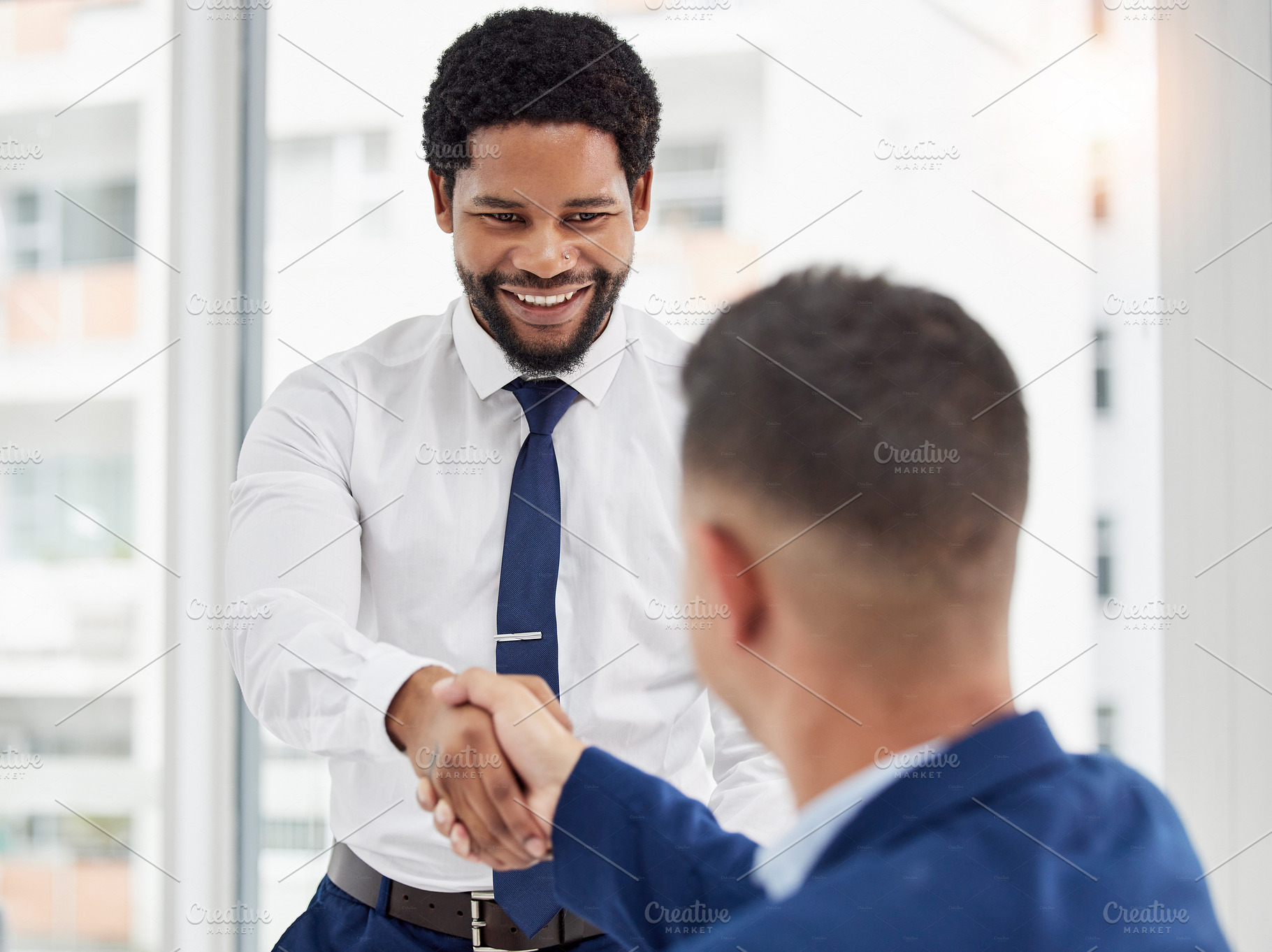 Businessman, handshake and meeting in partnership for deal, agreement or introduction at the office. Black man employee shaking hands with colleague for b2b, teamwork or collaboration at workplace, a Photo by Peopleimages.com