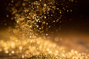 Golden glitter falling onto a shimmering surface, creating a festive sparkling, a Photo by Studio ANNA