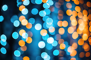 Vertical strings of glowing blue and orange bokeh lights in a fe, an Abstract Photo by José Manuel Gelpi