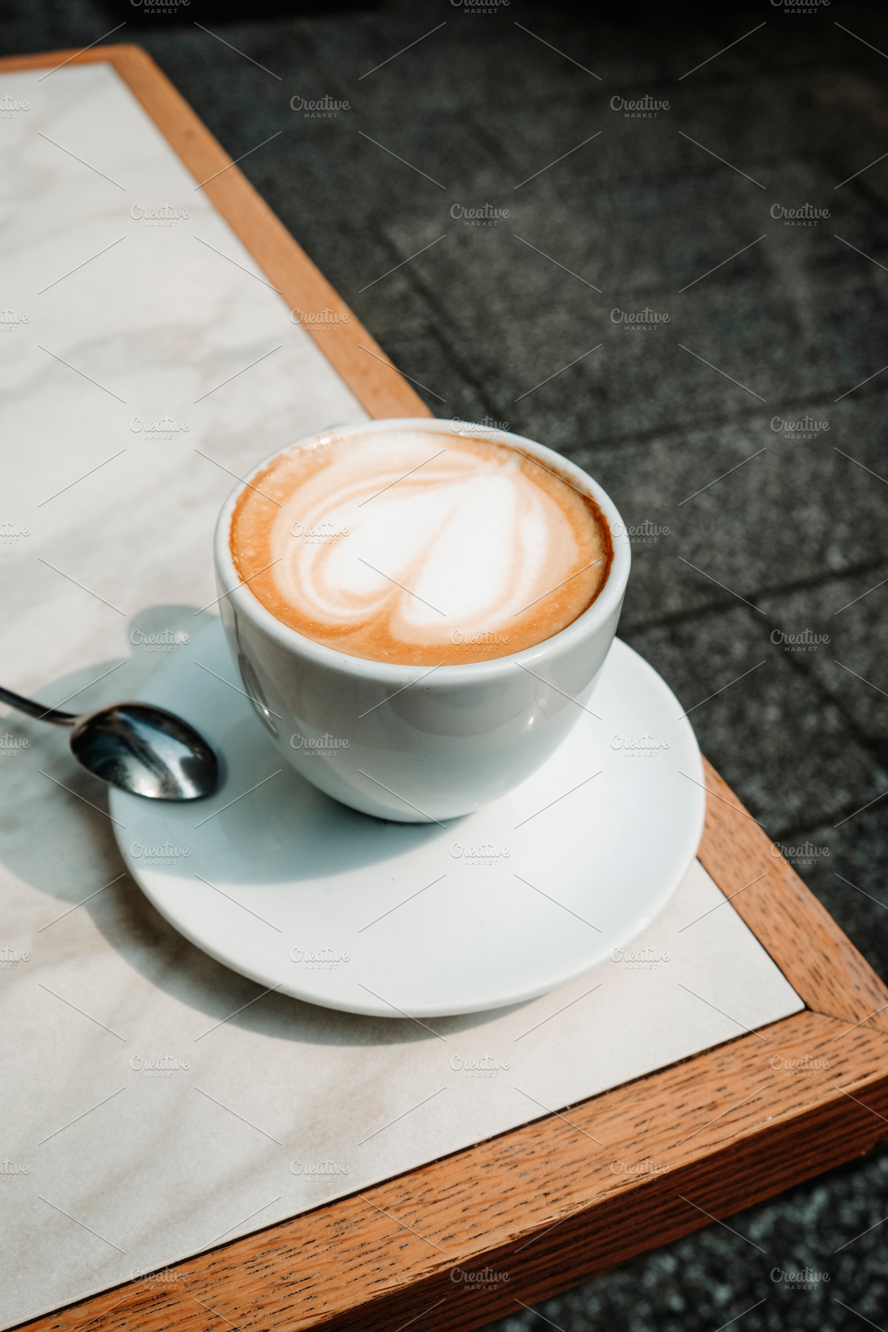 macchiato with heart shaped foam on a terrace table, a Photo by Nito