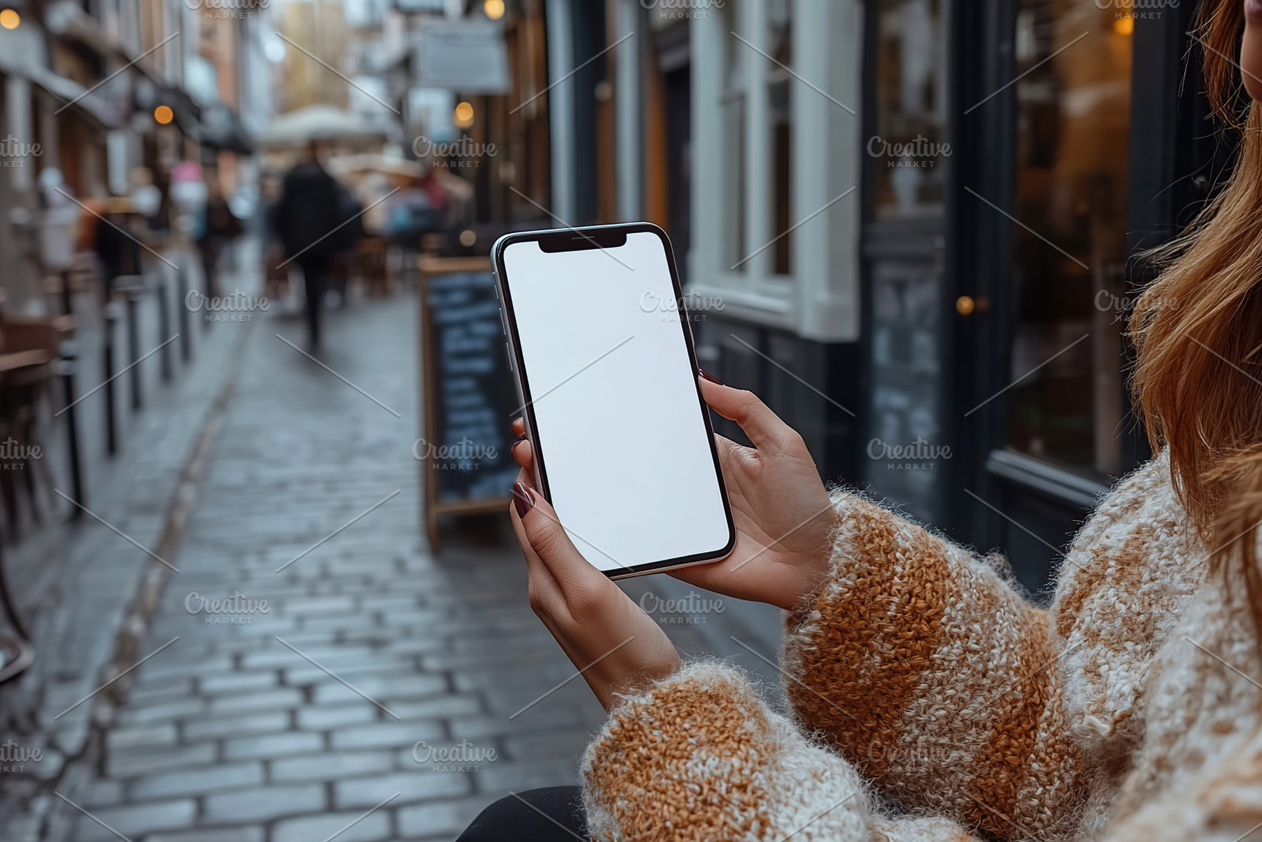Portrait of a person holding a blank mobile phone in a narrow street, a Technology Photo by AlyaAnd