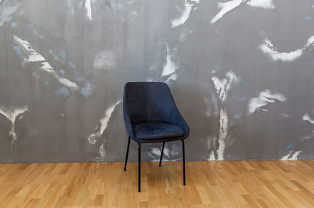 Black chair against a gray wall, an Arts & Entertainment Photo by Photostock