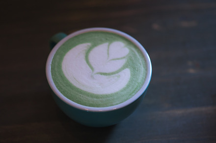 A cup of green matcha latte tea on the table, latte art, a Food & Drink Photo by PavelKant