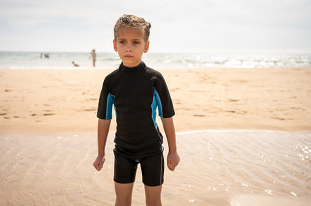 Little girl surfer in wetsuit standing ocean beach, a Person Photo by andreonegin market
