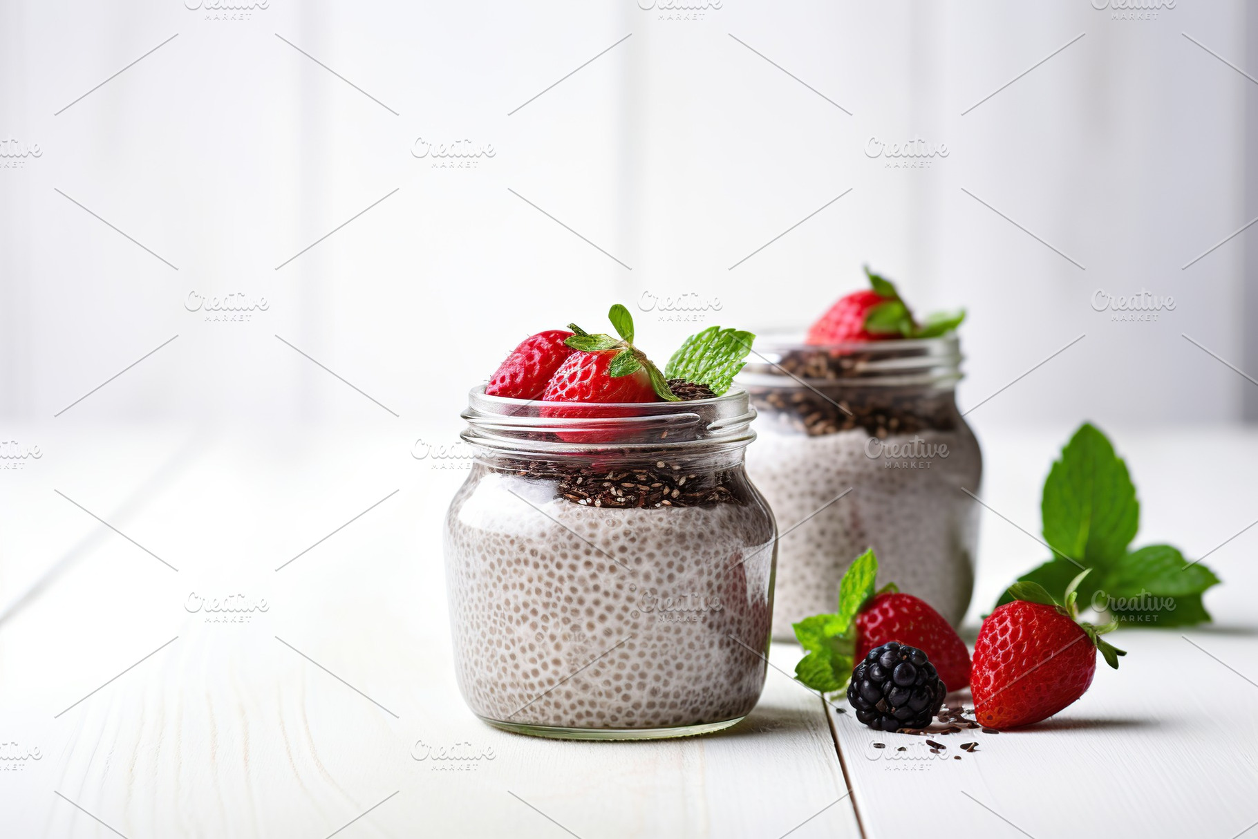 Chia pudding with berries in glasses on white background, a Food & Drink Photo by AlyaAnd