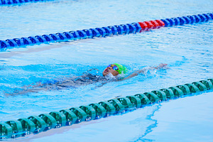 Swimmer child swims backstroke swimming style in a race swimming