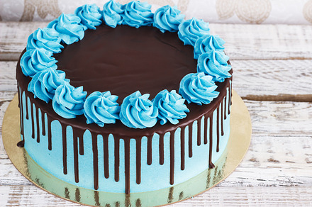 Birthday cake with cream chocolate drips on a white background containing