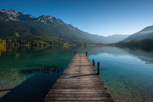 Wooden dock on a calm mountain lake, a Nature Photo by AlyaAnd
