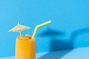 Glass of mango smoothie. Yellow slus