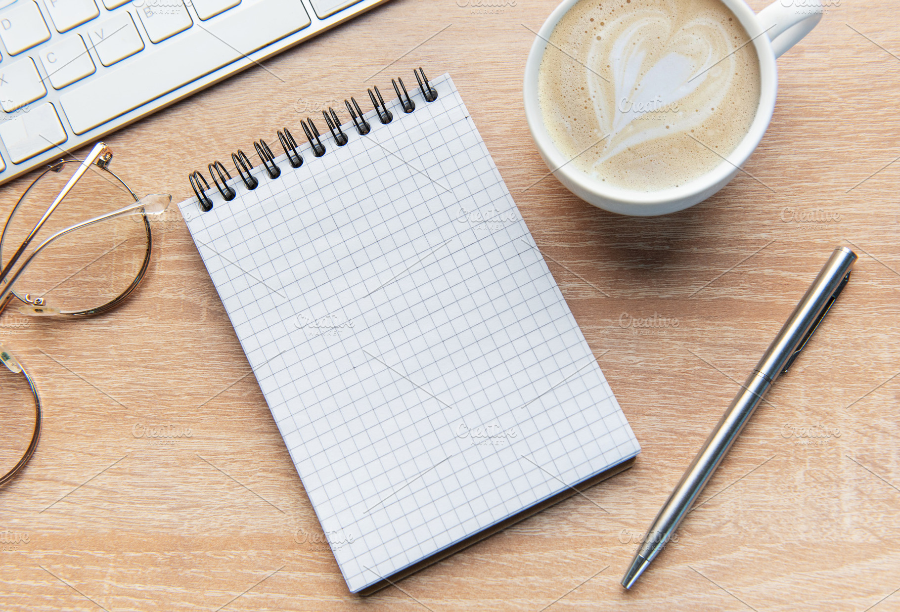 Desk with notepad, keyboard, coffee, pen, and glasses, a School & Education Photo by Olena Rudo