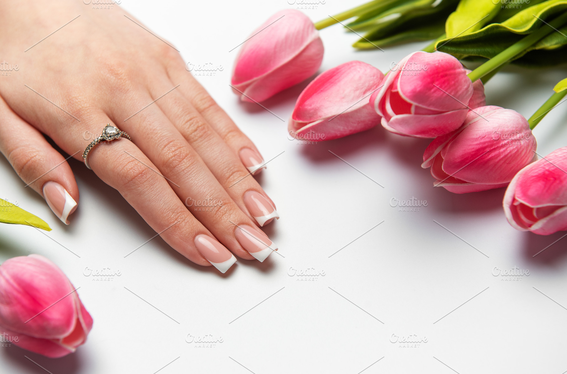 Woman showing french manicure near pink tulips on white backgrou, a Beauty & Fashion Photo by Olena Rudo