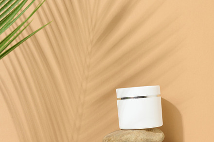 white round plastic jar for cosmetic products on a brown backgro, a Beauty & Fashion Photo by ndanko