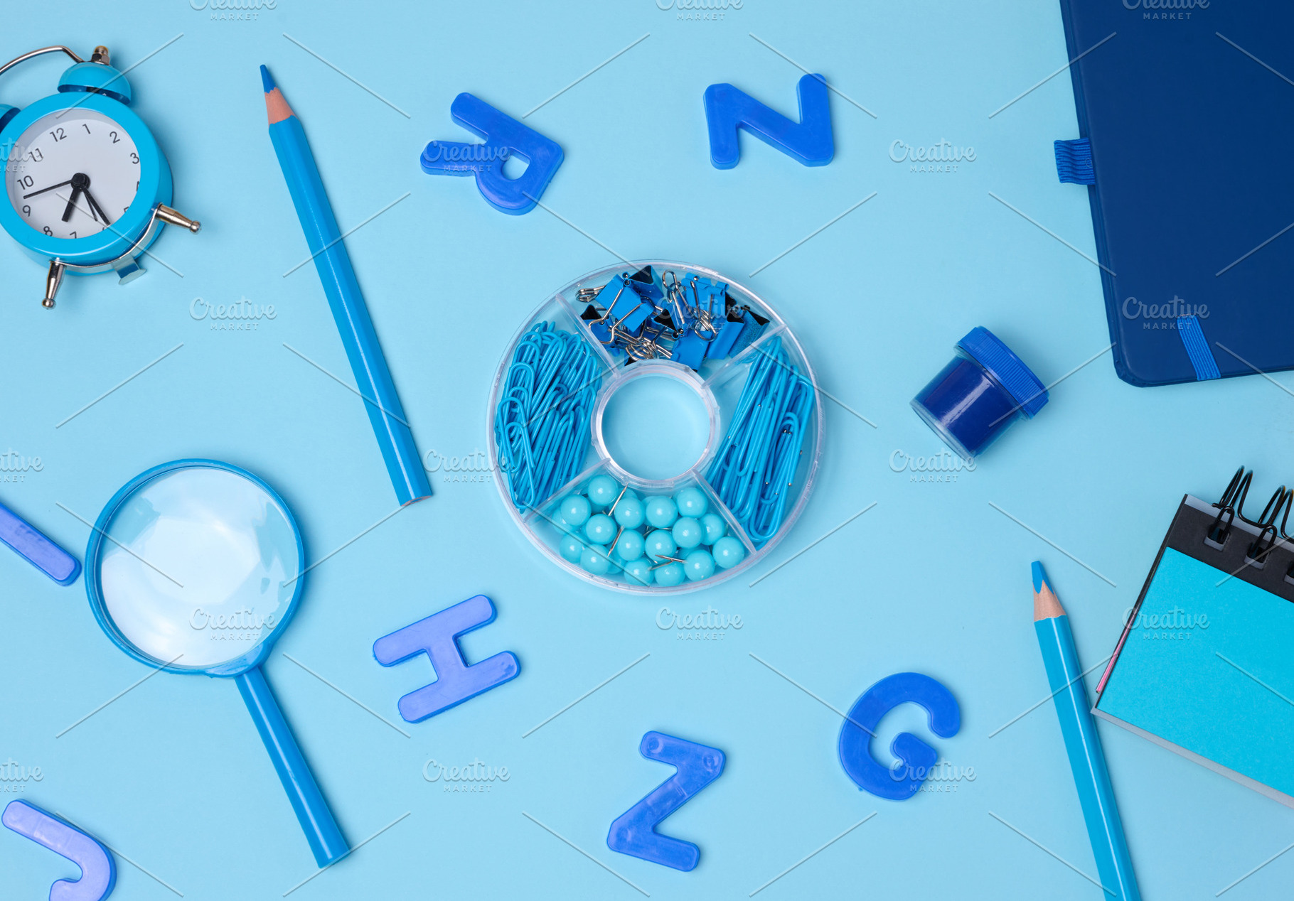 Flat lay of blue stationery, learning items letters, magnifying, a School & Education Photo by ndanko