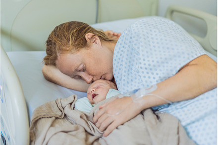 A baby lies with the mother after