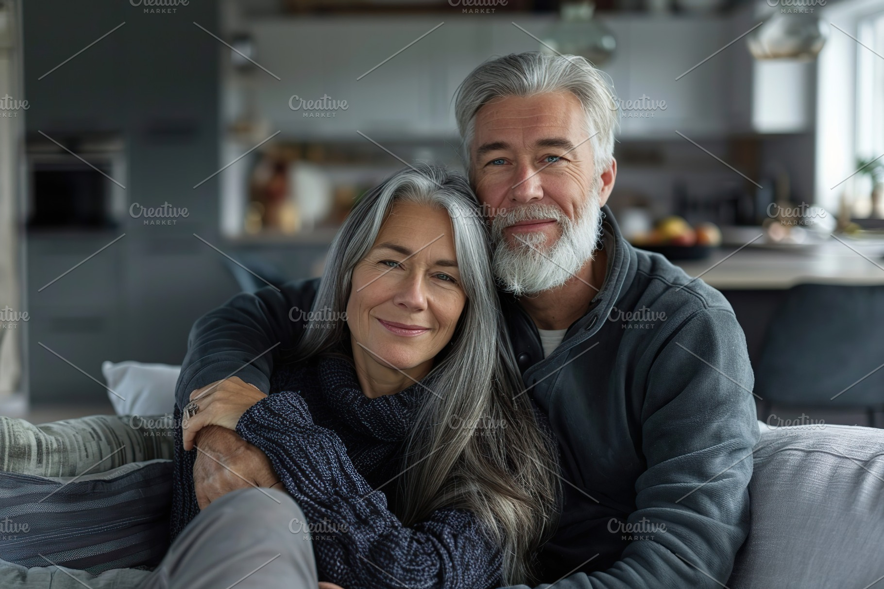 Portrait of happy mature couple sitting on grey couch at home, a Person Photo by AlyaAnd