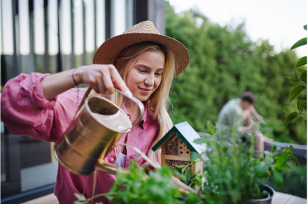 Young woman taking care of her herbs, a Person Photo by HalfPoint
