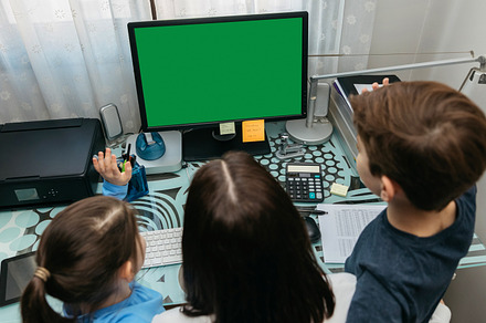 Mother and children looking at computer screen, a Person Photo by davidpereiras