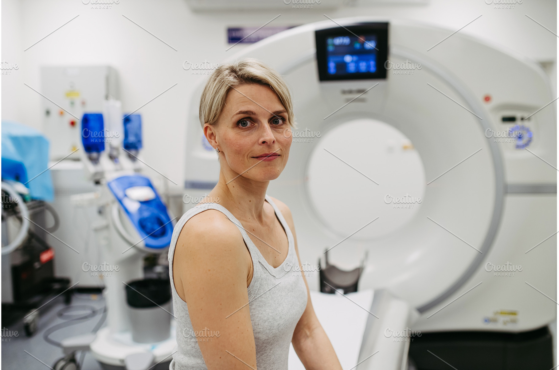 Woman sitting on CT scanner bed, a School & Education Photo by HalfPoint