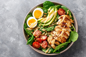 Healthy grilled chicken salad bowl with avocado and eggs, a Food & Drink Photo by AlyaAnd