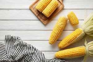 Sweetcorn on wooden background rusti, a Photo by Pixeness Studio