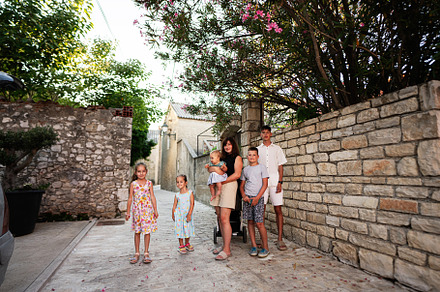 Happy family with children standing together outdoors by a stone wall in Nin, C, a Person Photo by AS photostudio
