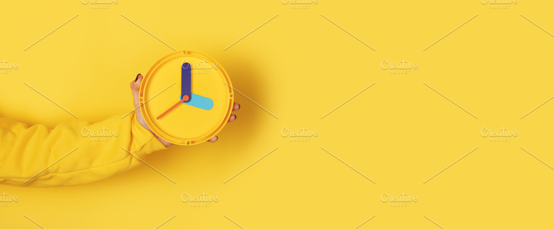 Minimalist yellow clock held by hand on solid yellow background,, a Holiday Photo by Ales Munt