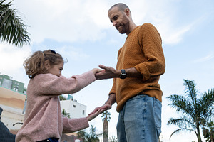 Father helping his daughter practice balance and coordination outdoors, a Person Photo by etorres69