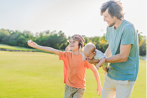 Father with his two sons in the park, a Person Photo by Elizaveta Galitskaya