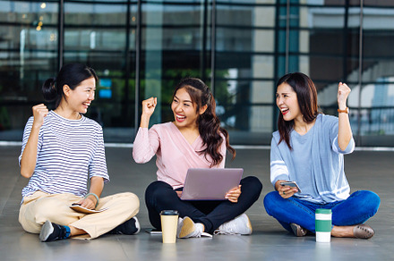 Asian students sitting on floor featuring women, showing, and fist up, a Person Photo by Twinster Photo
