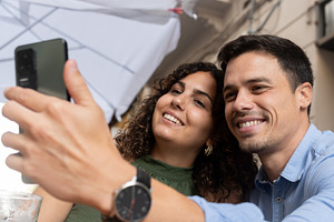 Young couple taking selfie with smartphone while drinking beer at restaurant te, a Person Photo by etorres69
